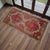 Authentic small rug featuring coral-red and sage tones with traditional Anatolian motifs — perfect for entryways,...