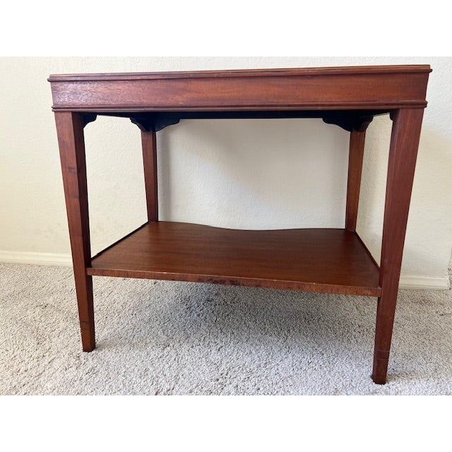 This is a Hepplewhite-inspired occassional table featuring a banded inlay detail, tapered legs, decorative fan inlays and...