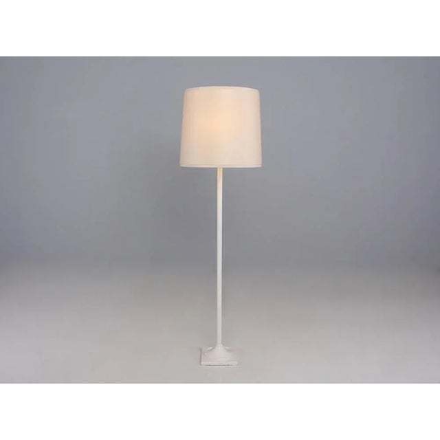Floor lamp in white lacquered steel, with 4 lights (three lateral adjustable), 2 lighting phases (high/low). Around 1950....