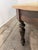 Large round dining table featuring a natural pine plank top with visible grain, knots, and a beautifully aged finish. The...