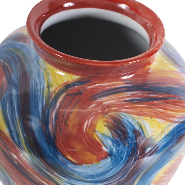 This vase boasts a unique and vibrant swirl of colors, reminiscent of brush strokes capturing the essence of blue skies,...