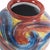This vase boasts a unique and vibrant swirl of colors, reminiscent of brush strokes capturing the essence of blue skies,...