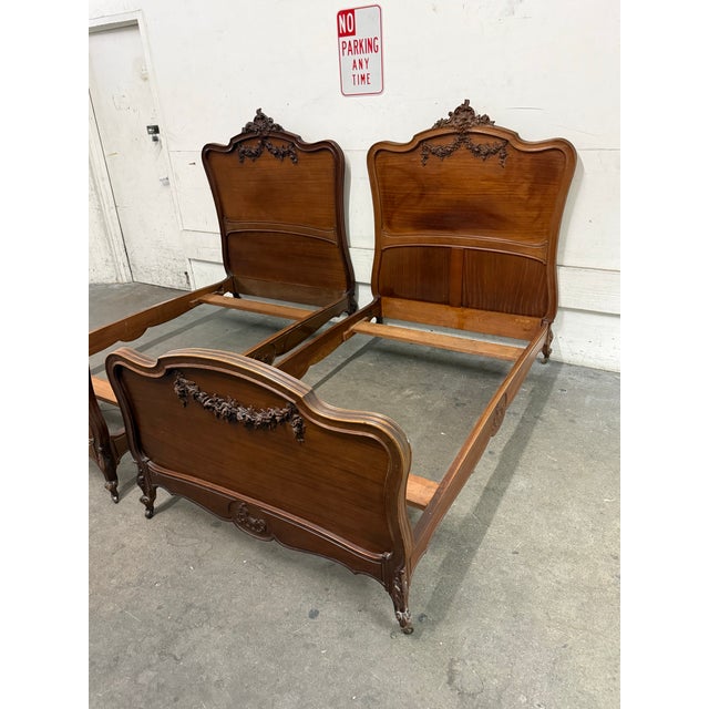 Design Plus Gallery presents a pair of Twin Size Louis XV Style Antique Carved Wood Bed Frames. Each frame showcases a...