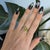 A natural sphene blazes with green-gold fire that surpasses a diamond's at the heart of this ring, framed by earth-mined...