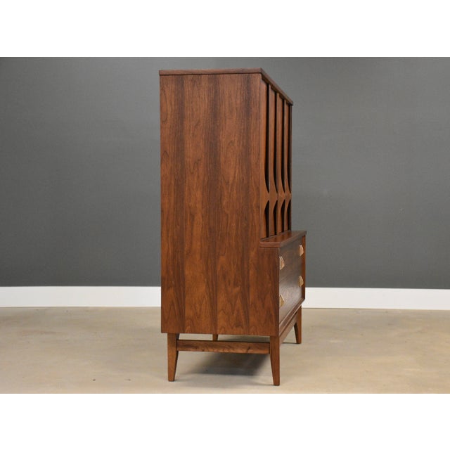 A mid century modern walnut tall six dovetail drawer dresser with polished brass drawer pulls made by Broyhill Brasilia....