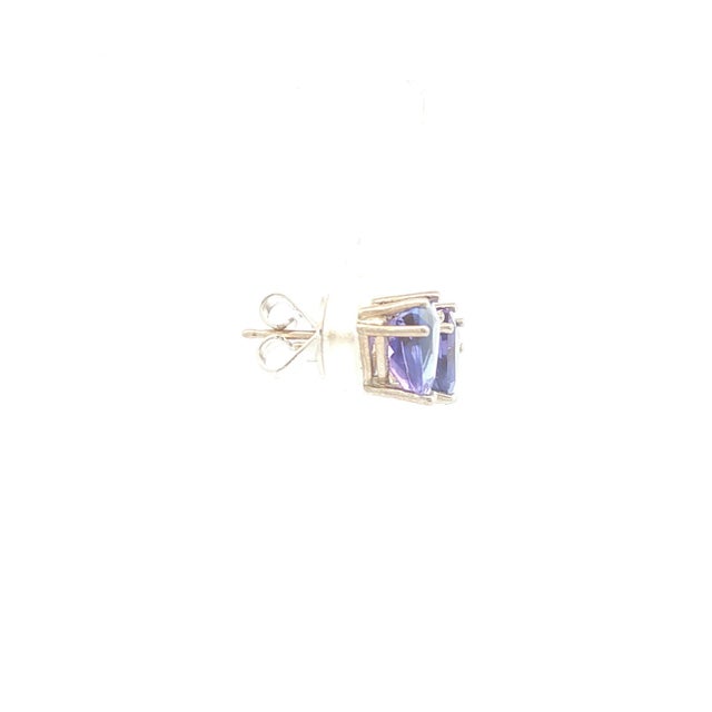 A pair of 14k white gold tanzanite stud earrings. Featuring trillion-cut purple tanzanite stones, they have a total carat...