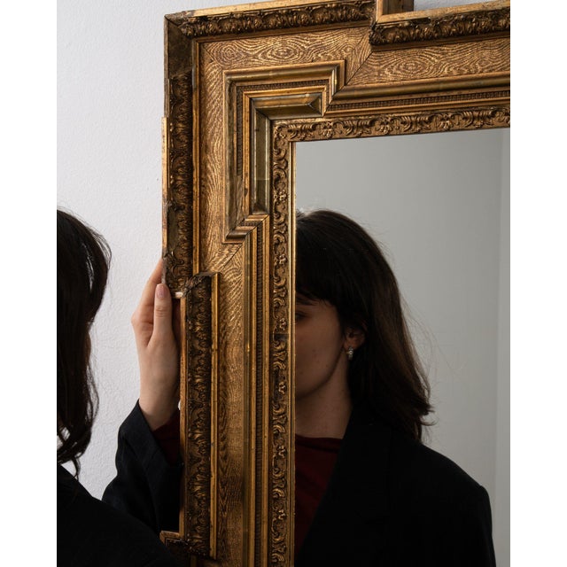 This mirror carries genuine presence, its gold gilt geometric stepped frame immediately setting the tone for the piece....