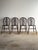 Antique Windsor dining chairs crafted in solid wood with wheel-back designs, sculpted plank seats, and turned legs. The...