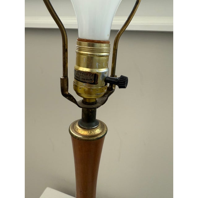 Classic mid-century modern table lamp featuring a sculptural ceramic base with a speckled off-white finish and a warm...