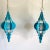 Gorgeous pair of large blue enameled Moroccan-style pierced metal pendant lights with elongated frames, rounded fins, and...