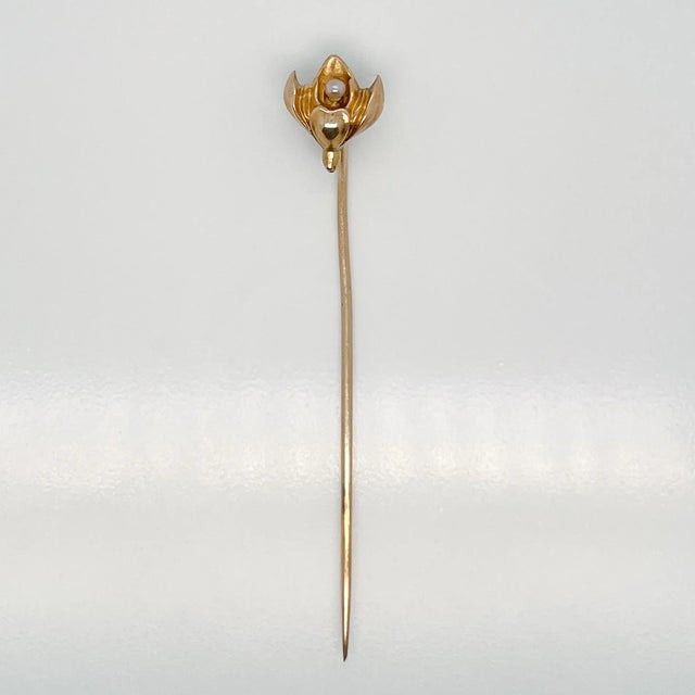 A very fine Late Victorian 10k gold & seed pearl stick pin. With a lotus shaped flower that has a small white round seed...