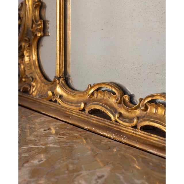 Console table and mirror with decorated gilded wooden structure and marble top, Rococo style, early 1900s.