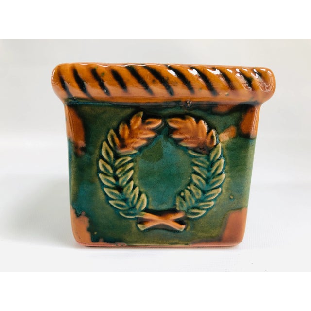 Vintage glazed terracotta planter cachepot decorated in relief with laurel wreath motif on two sides. No maker's mark.