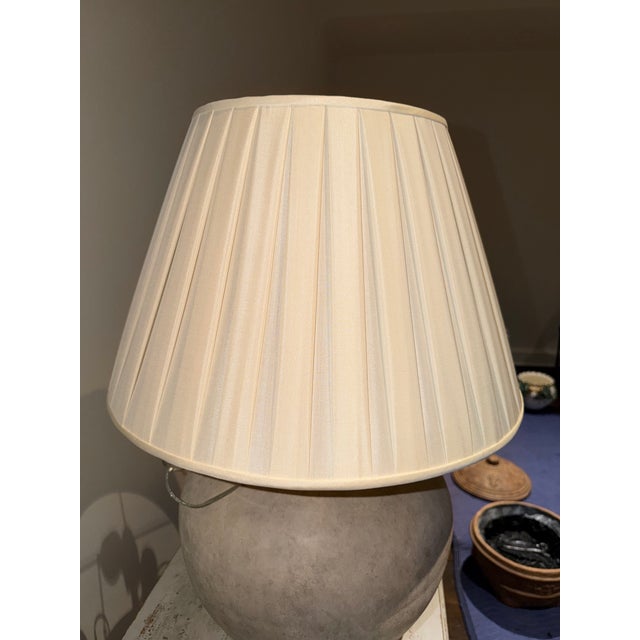 Gregorious Pineo Rondure Lamp. Dimensions are 13” diameter 28” H. The finish is Limestone. Shade included. Price is $1,800.