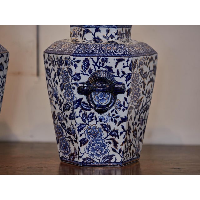 A pair of English blue and white porcelain lidded hexagonal pot pourri pots from the 19th century with dog finials....