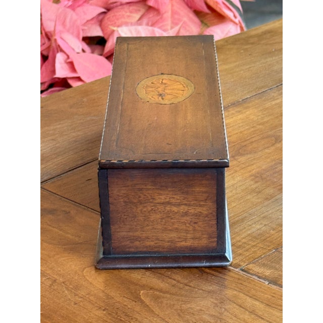 Small rectangular box with a hinged lid, decorated with oval shell inlay panels to the lid and front. The case is outlined...