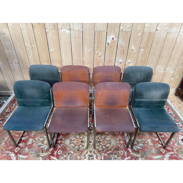 Set of eight dining chairs, circa 1970, with stainless steel sled bases and square bands, characteristic of the decade's...