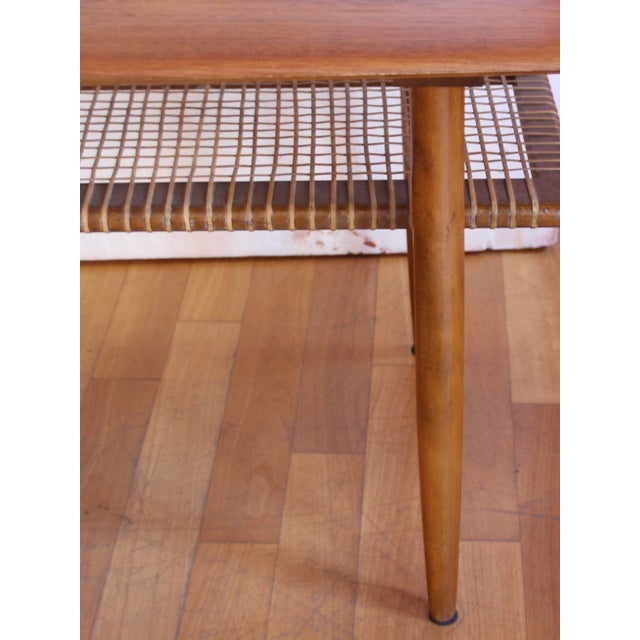 Teak wood side or coffee table in excellent condition. The top is made of teak wood, and the lower shelf is made of woven...