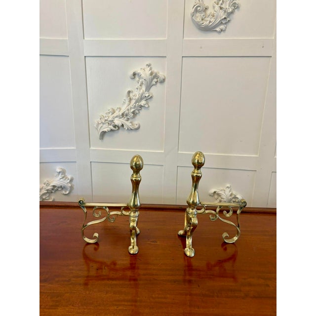 Pair of antique Victorian quality brass fire dogs having a brass turned shaped column with an oval top standing on shaped...