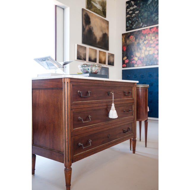 Elegant Louis XVI mahogany commode from the mid-19th century, topped with a smooth white marble surface. This refined...