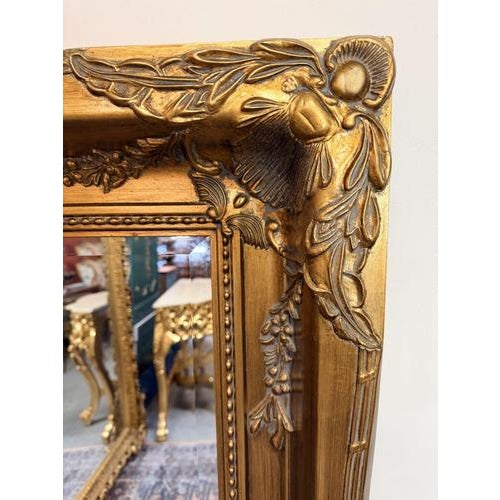 An impressive rectangular mirror with a richly gilt, thick double frame, finely decorated with scrolling forms and foliate...