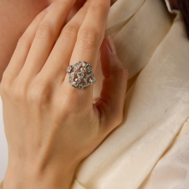 A striking embodiment of 1930s sophistication, this authentic Art Deco ring showcases an intricate array of forty-five...