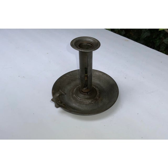 18th century American primitive candle holder. Finger holder attached to a rounded catch base.
