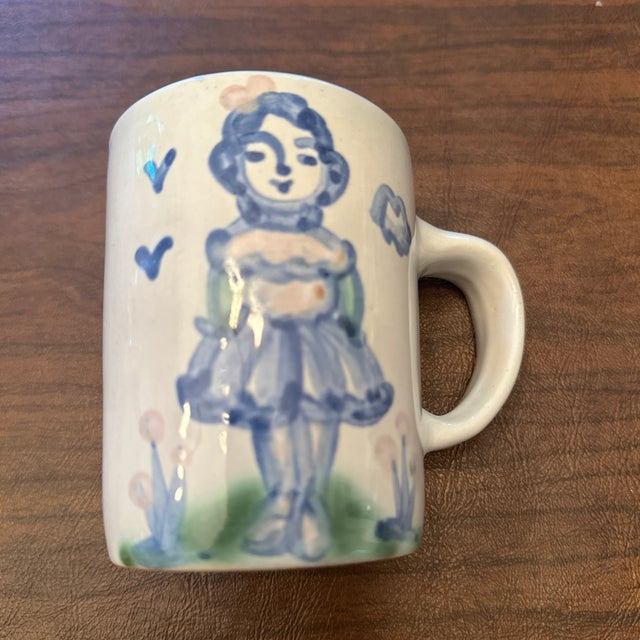 Delightful Mary Alice Hadley original coffee mug with young girl, flowers, and birds on front. Signed on bottom. Hadley...