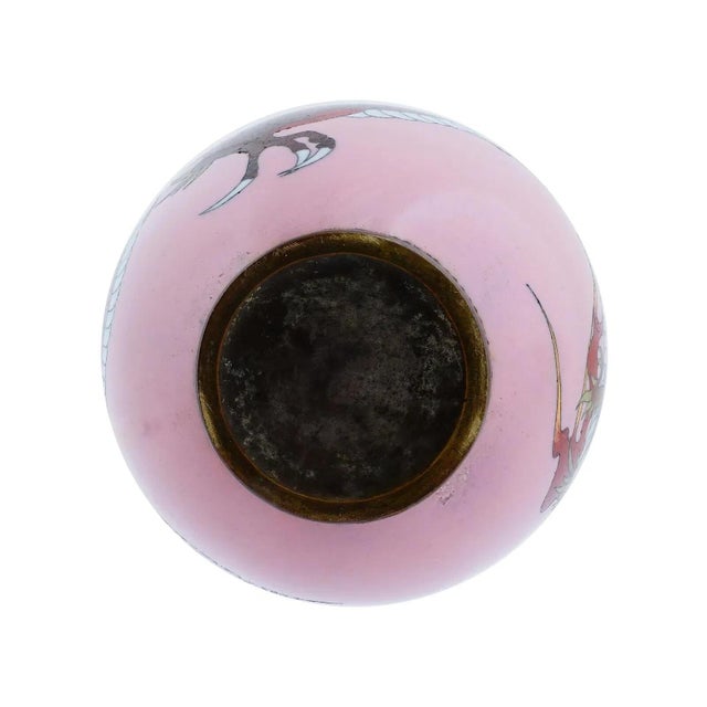 A Japanese enamel over copper vase. The vase has a globular shaped body and a narrow neck with a fluted mouth. The vase is...