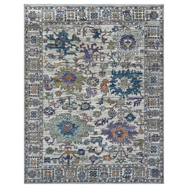 A soft, faded ivory Oushak area rug with the washed-out look of a century-old piece. Oversized palmettes in slate blue,...
