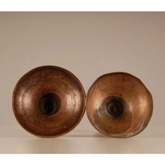 A pair contemporaneous candlesticks Vase form body, bell nozzle and a stepped base Material: bronze To be dated: first...