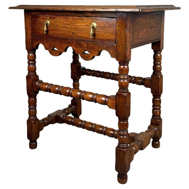 A beautifully crafted early 20th century oak side table in the Chippendale style, dating to circa 1910, showcasing the...