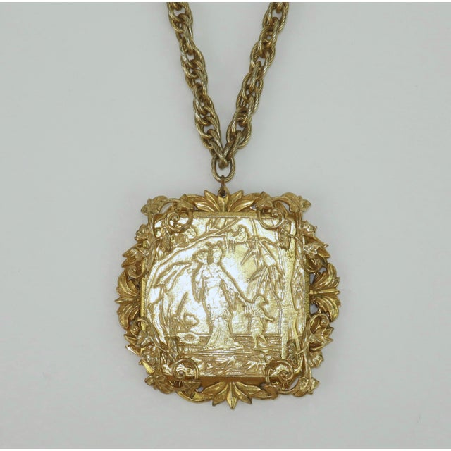 Ornate Miriam Haskell gold plated medallion pendant suspended from a twisted chain link necklace outfitted with a safety...