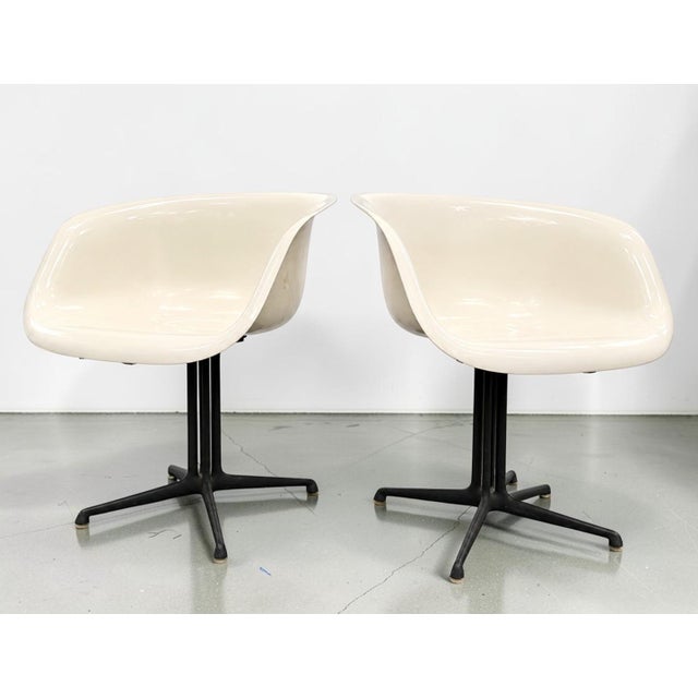 Set of four vintage Eames molded fiberglass chairs for Herman Miller, including two armchairs and two armless side chairs....