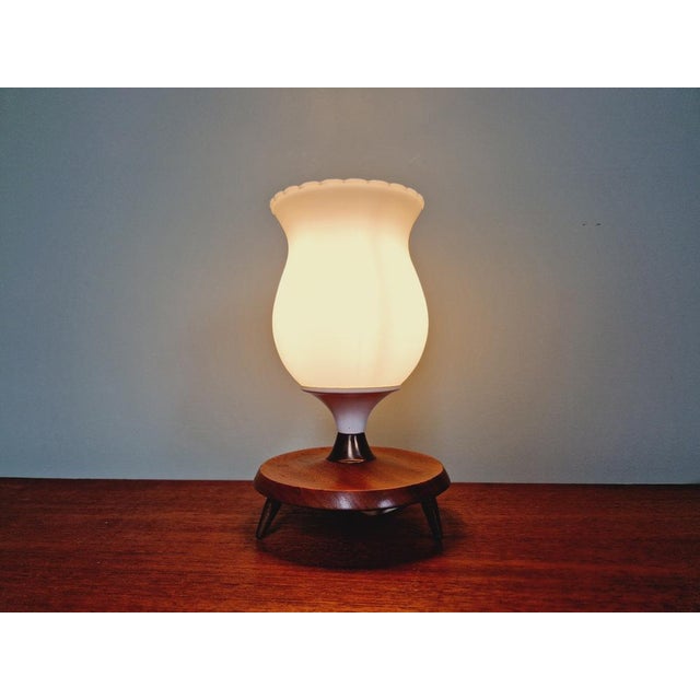 Scandinavian tripod lamp from the 60s with a white opaline glass bobbèche and a teak and brass foot. The electric sheet...