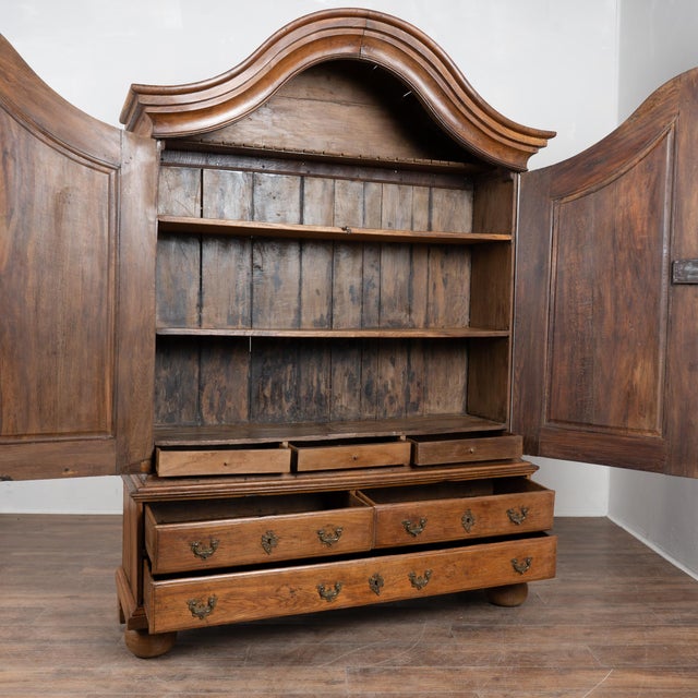 Late 18th-century Swedish oak tall Rococo cabinet with deep aged patina and a dramatic curved bonnet crown. The lower...