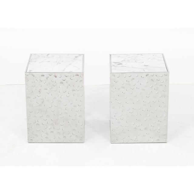 Pair of Gallet and Dauzet "Brady" Side Tables, textured Carrara iceberg marble tops above hand-hammered stainless steel...