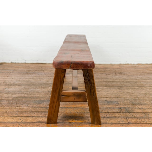 An antique long A-Frame wooden bench with rustic appearance and H-Form stretcher. Immerse yourself in the rustic charm of...