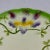 A Sarreguemines French Barbotine faïence majolica plate showing a spray of three purple and yellow orchids on a cream...