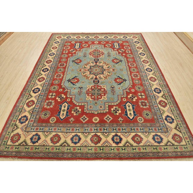 A traditional tribal Caucasian Kazak rug hand-knotted with an all-wool pile on a cotton foundation. This oriental rug...