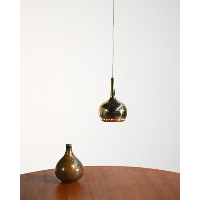 Polished brass ceiling lamp with decorative perforations along the lower edge. Designed by Hans-Agne Jakobsson, Sweden,...
