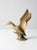 A mid-century brass duck figurine poised in flight, capturing the motion and grace of a bird rising from water. The...