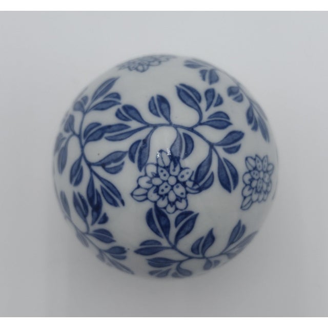 Delicate and timeless, this hand-painted blue and white porcelain sphere features a continuous floral vine motif rendered...