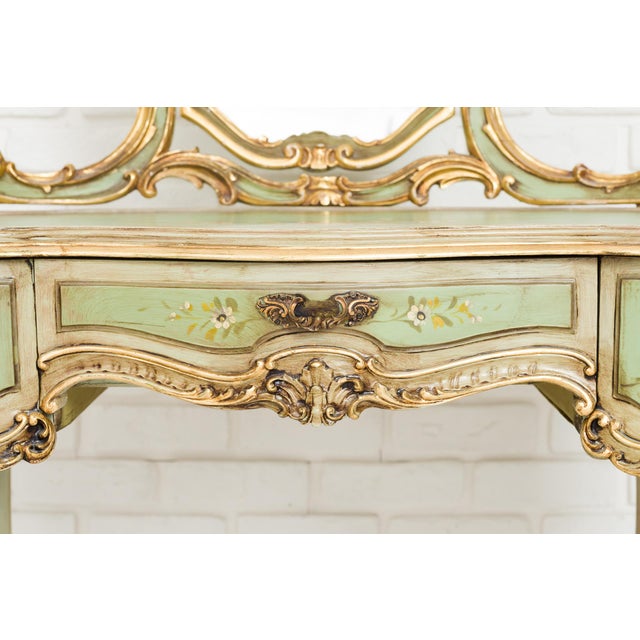 A French Louis XV / Rococo Revival–inspired dressing table made of carved wood with a green lacquered finish and gilt...