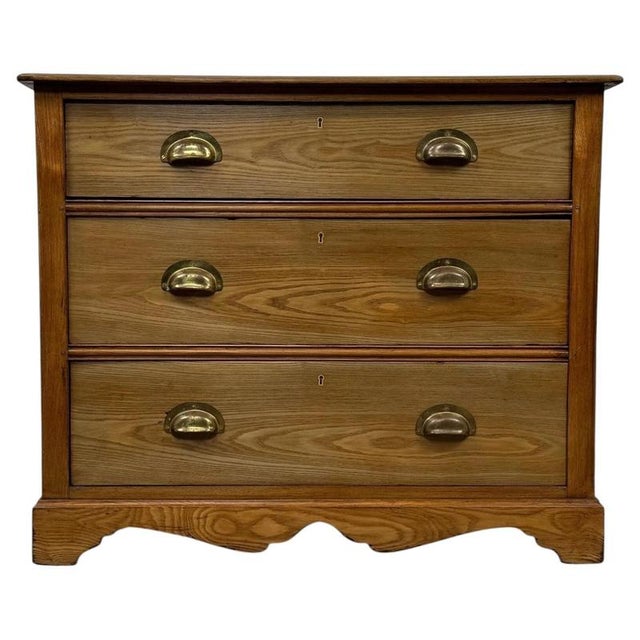 A handsome early 20th-century English chest of drawers, finely crafted from ash and distinguished by its beautifully...