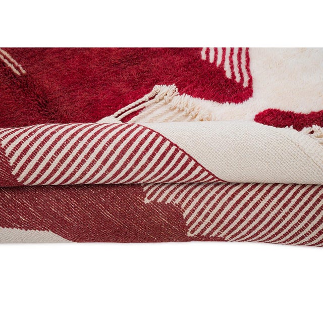 A striking silhouette, mirrored top to bottom. A dramatic burgundy medallion unfolds across a cream field, its sharp...