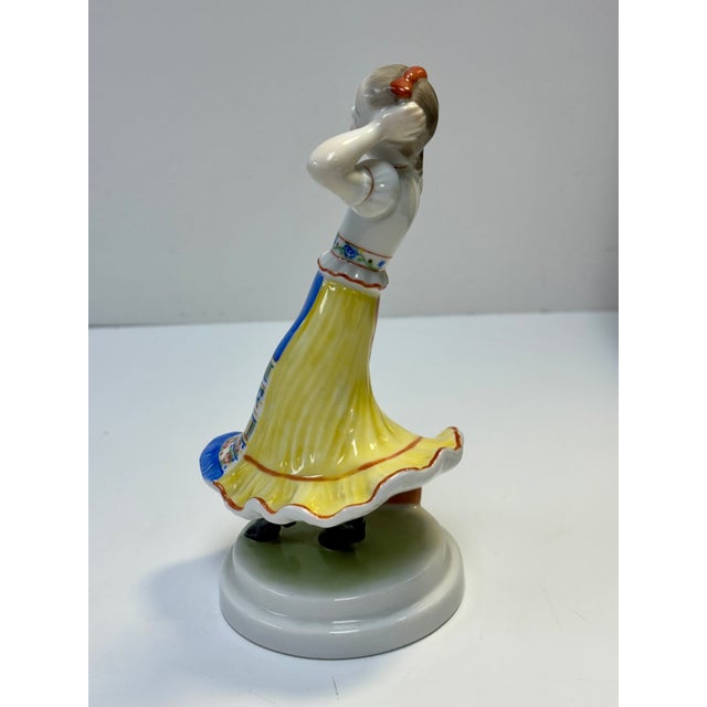A charming vintage handpainted Hungarian porcelain sculpture depicting a folk dancing girl in a traditional Hungarian...