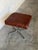 This square ottoman features a striking patchwork top over a minimalist tubular frame. The bold design creates an...