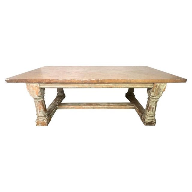 Rustic vintage dining table with a sturdy and traditional design. The top has a unique herringbone pattern in a light wood...