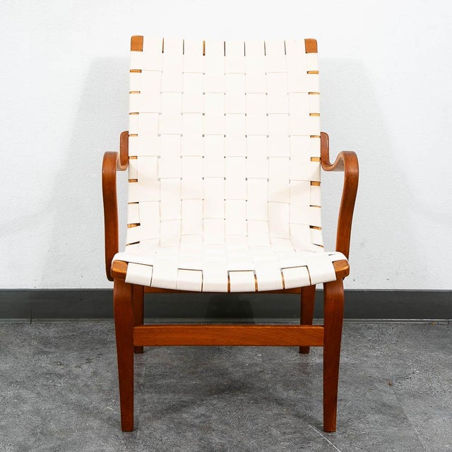 Iconic "Eva" armchair designed by Bruno Mathsson. It comes with frame of molded beech stretched with thick interwoven...